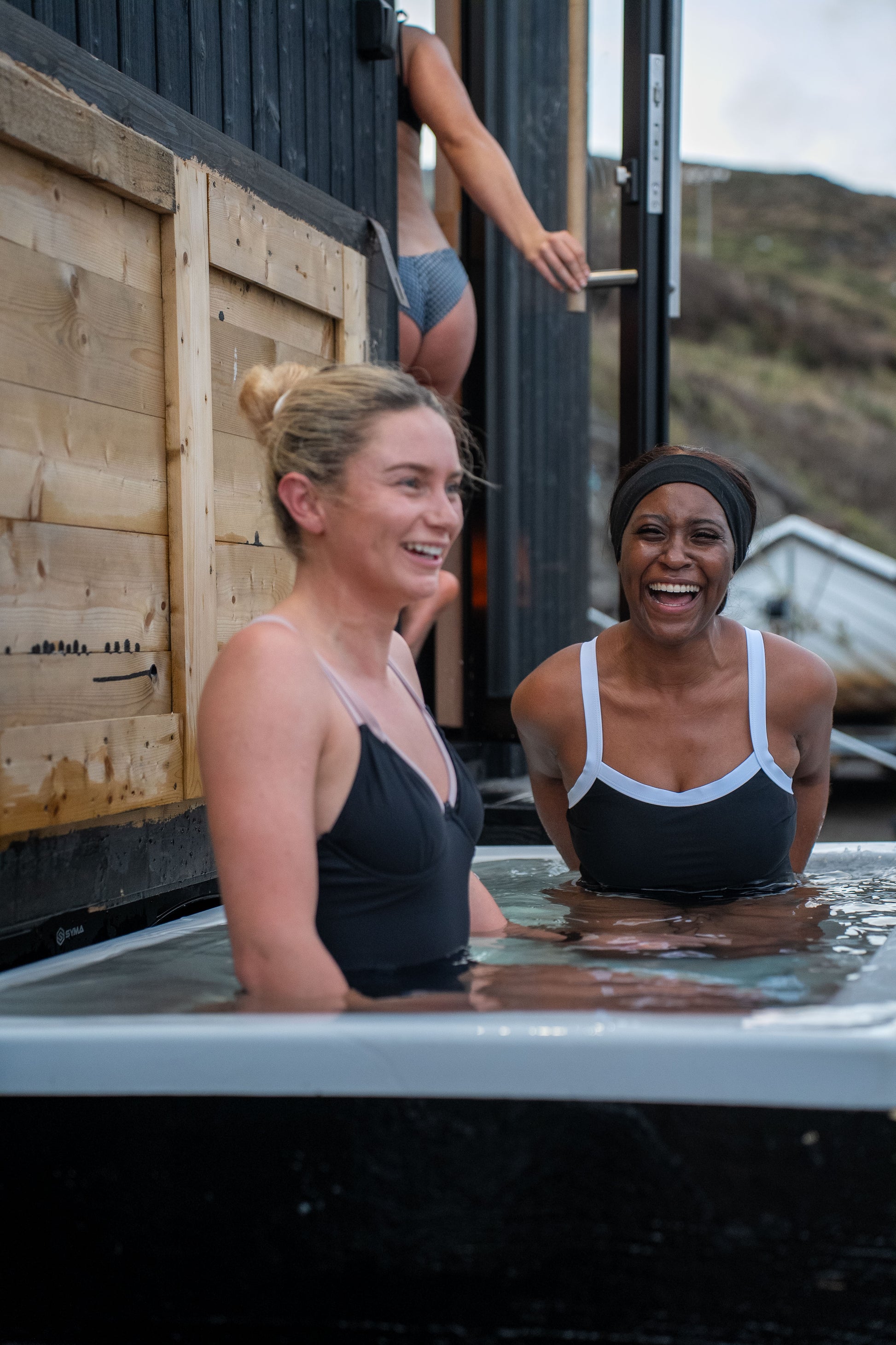 Guests enjoying the cold plunge beside the bespoke double wood-fired Sliabh Liag Sauna at Teelin Pier.