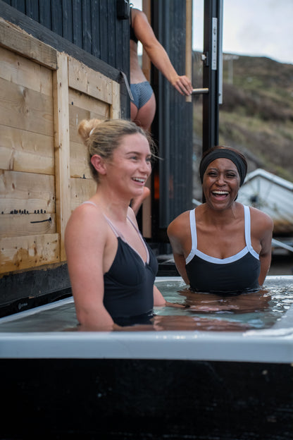 Guests enjoying the cold plunge beside the bespoke double wood-fired Sliabh Liag Sauna at Teelin Pier.