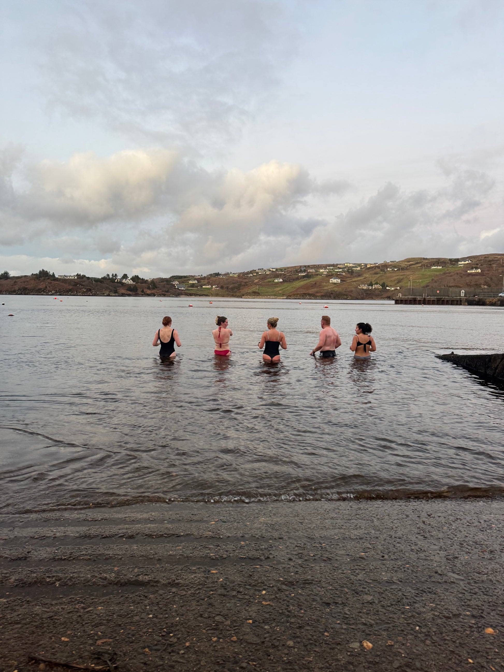 Group of guests taking a sea dip in Teelin Bay after their session in the bespoke double wood-fired Sliabh Liag Sauna.