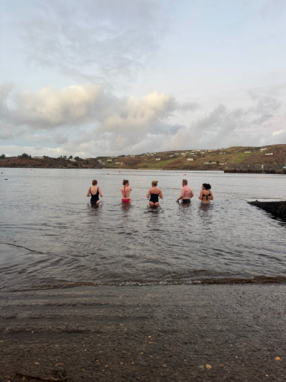 Group of guests taking a sea dip in Teelin Bay after their session in the bespoke double wood-fired Sliabh Liag Sauna.